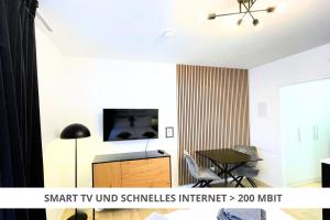 ein Wohnzimmer mit einem TV und einem Tisch in der Unterkunft Apartment Wahnfried No4 - Zentral wohnen mit Küche und Duschbad, Parkplatz, 300m zur Fussgängerzone in Bayreuth