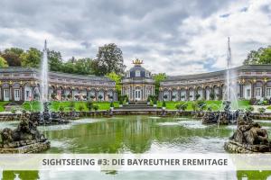 a large building with a fountain in front of a pond at Apartment Wahnfried No4 - Zentral wohnen mit Küche und Duschbad, Parkplatz, 300m zur Fussgängerzone in Bayreuth