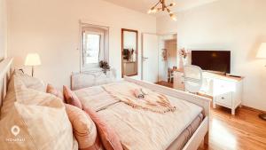 a white bedroom with a bed and a television at Zentrales Turm-Apt mit Terrasse in Amberg