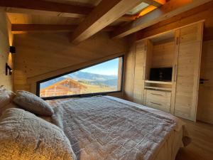 um quarto com uma cama e uma grande janela em Chalet Mont-Reve em Font Romeu Odeillo Via
