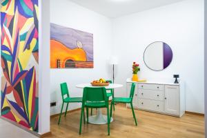 een eetkamer met een tafel en stoelen en een schilderij bij CheckBelgradeApartments - Colors in Belgrado