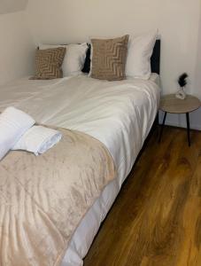 a bedroom with two beds with white sheets and a table at VRY NICE PLACE London in London