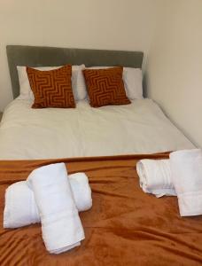 a bed with two stacks of white towels on it at VRY NICE PLACE London in London