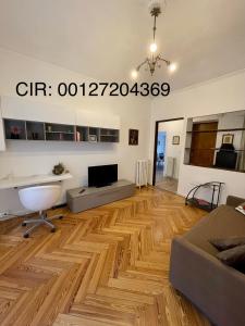 een woonkamer met een houten vloer en een bank bij La Casa di Titilla in Turijn