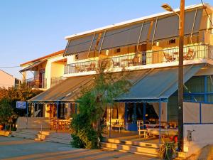 a building with tables and chairs in front of it at Lefteris in Polichnítos