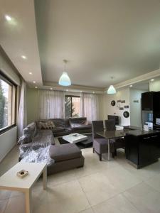 un soggiorno con divano e tavolo di 2 bedroom apartment in abdoun a Umm Uthainah