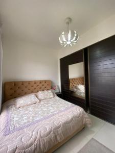 una camera con un grande letto e un lampadario a braccio di 2 bedroom apartment in abdoun a Umm Uthainah