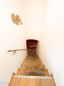 a staircase in a room with white walls and wooden floors at Appartements de charme - Vidéoprojecteur et SPA en centre ville in Montpellier