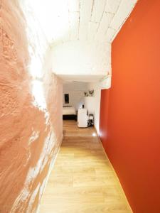 a hallway with an orange wall and a room at Appartements de charme - Vidéoprojecteur et SPA en centre ville in Montpellier