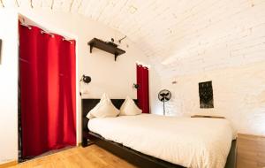 a bedroom with red curtains and a white bed at Appartements de charme - Vidéoprojecteur et SPA en centre ville in Montpellier