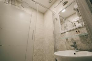 a white bathroom with a sink and a shower at Mirabilia House Termini in Rome