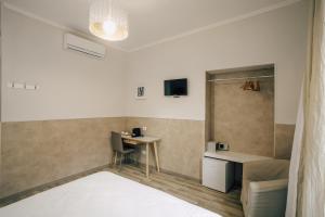 a room with a bed and a table and a desk at Mirabilia House Termini in Rome