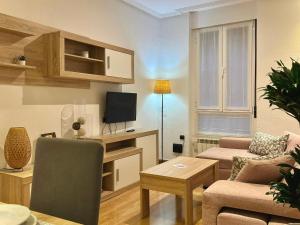 a living room with a couch and a tv at Blue et Rose by ARoom VUT-LE-966 in León
