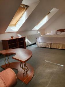 Schlafzimmer mit einem Bett, einem Schreibtisch und einem Tisch in der Unterkunft Hotel Margit in Trenčianske Teplice