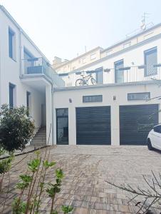 a white house with a garage with a car parked in front at Cozy Apartments in Central Location with Free Parking on Availability in Vienna