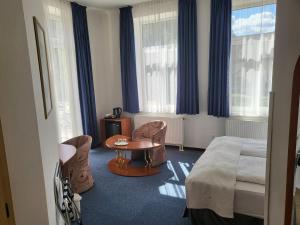 une chambre d'hôtel avec un lit, une table et des chaises dans l'établissement Hotel Margit, à Trenčianske Teplice