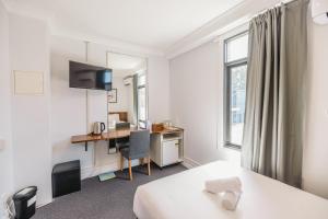 a hotel room with a bed and a desk at Newtown Cozy Stays in Sydney