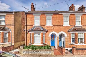 a red brick house with a blue door at Warm and Spacious Smart Stay - Close to Harry Potter World and mainline station connecting to London and Luton Airport - Contractors and corporate bookings welcome in St. Albans