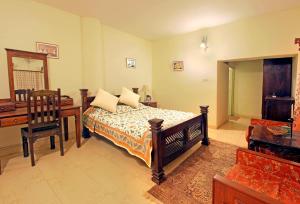 1 dormitorio con cama, escritorio y silla en Bhadrawati - A Riverside Safari Lodge Ranthambore, en Sawāi Mādhopur