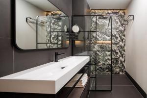 a bathroom with a sink and a mirror at Bucharest Comfort Suites Hotel in Bucharest +60 photos