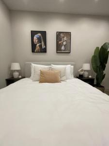 een slaapkamer met een groot wit bed met 2 lampen bij Amsterdam Grachtenappartement in Amsterdam