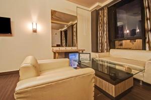 a living room with two couches and a glass table at Collection O Hotel My Stay Inn II in Jaipur