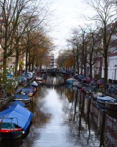een rivier met boten aan de zijkanten geparkeerd bij Amsterdam Grachtenappartement in Amsterdam