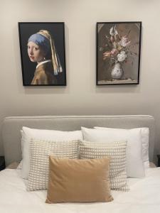 een slaapkamer met twee foto's van een vrouw en een vaas met bloemen bij Amsterdam Grachtenappartement in Amsterdam