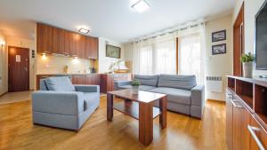 een woonkamer met een bank en een tafel bij Rozewie, Sun & Snow in Jastrzębia Góra
