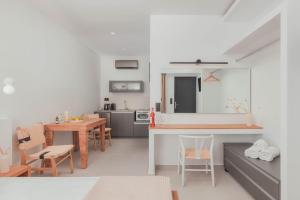 Plakakia Luxury Apartments في ماكري جيالوس: مطبخ وغرفة معيشة مع طاولة وكراسي