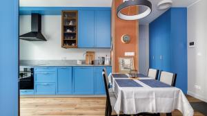 una cucina blu con tavolo e armadi blu di VENTI Św. Piotra 6 GDYNIA a Gdynia