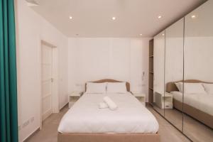 Schlafzimmer mit einem Bett und einem Spiegel in der Unterkunft Swieqi 3 bedroom apartment 1 in Is-Swieqi