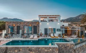 a villa with a swimming pool and a house at Plakakia Luxury Apartments in Makry Gialos
