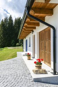 a building with two pots of red flowers in front of it at Chalupa Julia Staré Hutě in Horní Stropnice