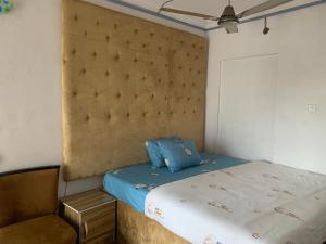 1 dormitorio pequeño con 1 cama y 1 silla en New Travellers Lodge Sangotedo Lagos, en Lekki