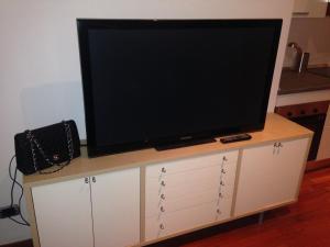 einen Flachbild-TV auf einem weißen Schrank in der Unterkunft Antonella's House in Bresso