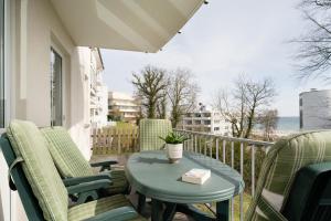 um pátio com uma mesa e cadeiras numa varanda em Residenz am Yachthafen Wohnung 3 em Grömitz