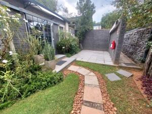 een tuin met een pad naar een gebouw bij Lieu De Grace in Johannesburg