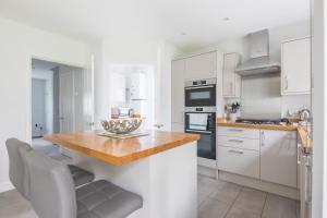 a kitchen with white cabinets and a wooden counter top at Detached 4-Bed home - Idyllic Village in Cambridge