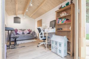ein winziges Haus mit einem Schreibtisch und einer Couch in der Unterkunft Detached 4-Bed home - Idyllic Village in Cambridge