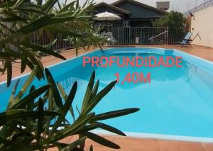 a blue swimming pool with a sign that readsauthorizedhandle at Pousada e Hotel Italian Garden House in Campo Grande