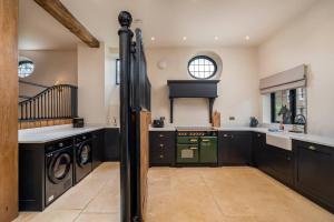 a kitchen with black cabinets and a green oven at Pass the Keys Merlin’s stables-country retreat in Brill