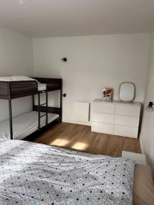 ein Schlafzimmer mit einem Bett und zwei Etagenbetten in der Unterkunft Appartement 4/6 personnes - Cornimont in Cornimont