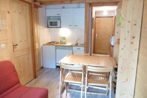 a small kitchen with a wooden table and chairs at Appartement centre d'Arêches, 4 personnes, 1 chambre - VLI29 in Beaufort