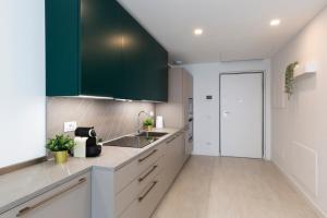 a kitchen with white counters and green cabinets at Terminal Tower 601 - San Cristoforo M4 in Milan