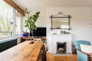 a living room with a wooden table and a fireplace at 2BR w park-view in S Newington in London