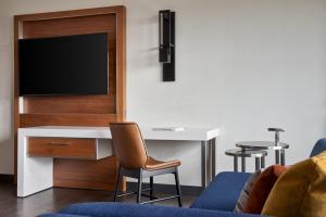 a hotel room with a desk and a tv at Marriott Owings Mills Metro Centre in Owings Mills