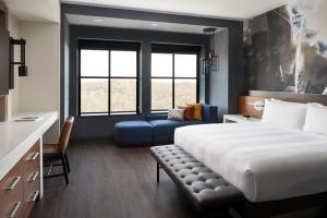 una camera con un grande letto e un divano blu di Marriott Owings Mills Metro Centre a Owings Mills