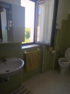 baño con lavabo y aseo y ventana en Casa Italia en Oratino