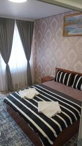 1 dormitorio con 1 cama con toallas en Готель Ассоль, en Khmelʼnytsʼkyy